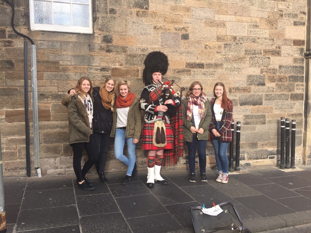 Austauschschülerin mit Freundinnen und Dudelsackspieler in Edinburgh